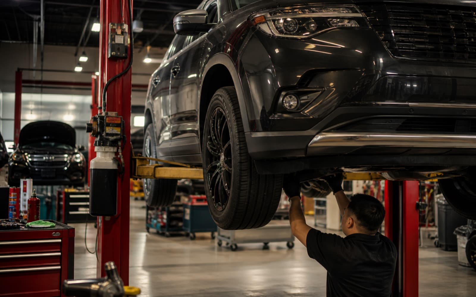 Technician checking a vehicle on a service lift